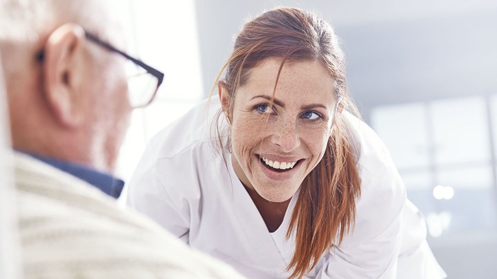 a female nurse helping an elderly patient